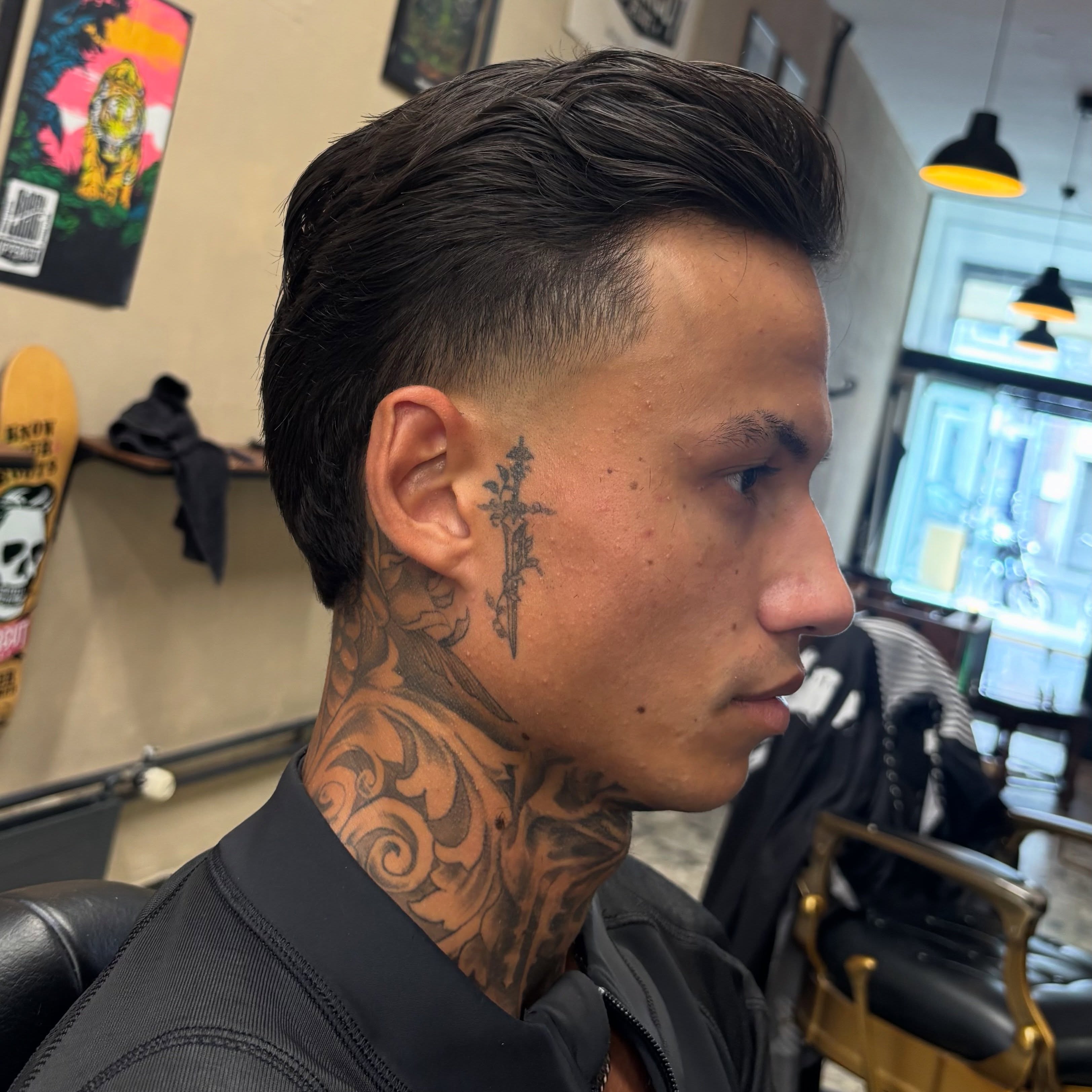 Klant met een strakke skin fade en lange lok bovenop, van opzij, in de shop